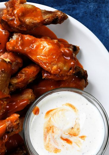 Baked Crispy Buffalo Chicken Wings Recipe - Crispy buffalo wings no longer have to be deep fried to be delicious! This easy recipe for baked chicken wings makes everyone's favorite wing even better! // addapinch.com