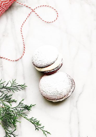 Red Velvet Cookies Recipe - These delicious cookies taste like your favorite red velvet cake in cookie form! Red Velvet cookies filled with cream cheese frosting and topped with a magical dusting of confectioner's sugar! // addapinch.com