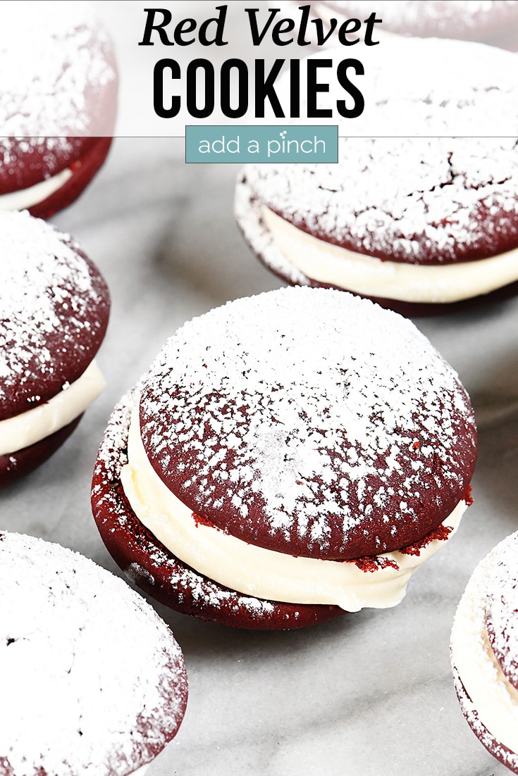 Red Velvet Cookies dusted with powdered sugar, served on a plate - with text - addapinch.com