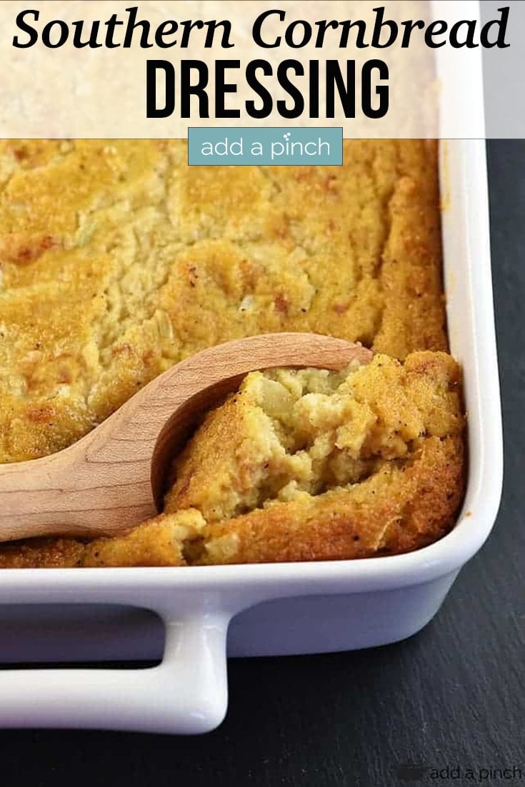 Southern Cornbread Dressing in white casserole dish scooped with wooden spoon - with text - addapinch.com