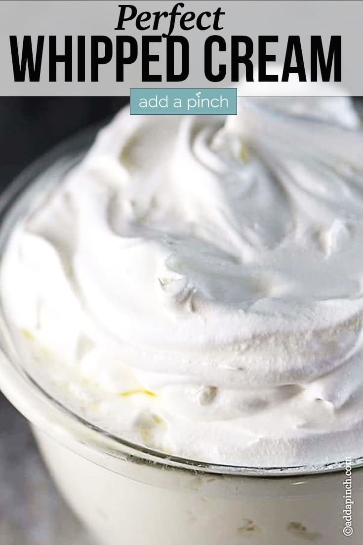Perfect Whipped Cream whipped into peaks in a glass bowl - with text - addapinch.com