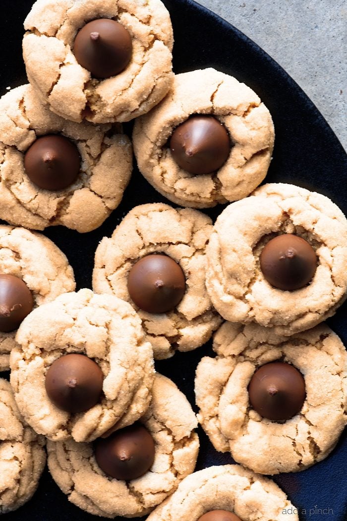 Peanut Butter Blossoms Recipe - This soft classic peanut butter cookie topped with a milk chocolate kiss is always a favorite! // addapinch.com