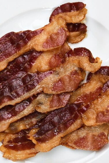 Photo of bacon on a white plate.
