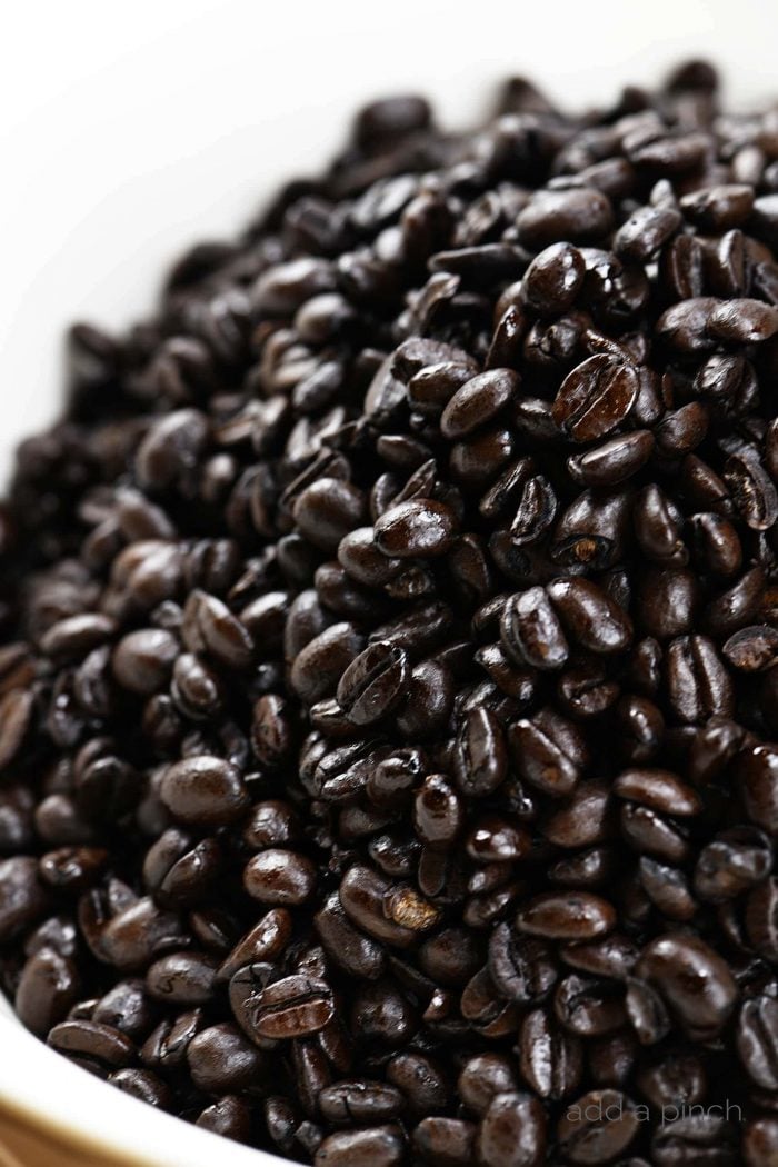 Espresso beans on a white surface.