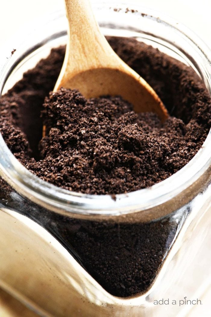 Espresso powder in a glass jar with a wooden scoop.