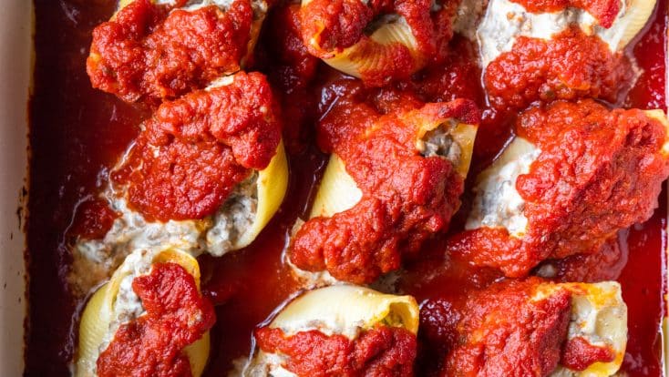 Photo of stuffed shells in a baking dish ready to be served.