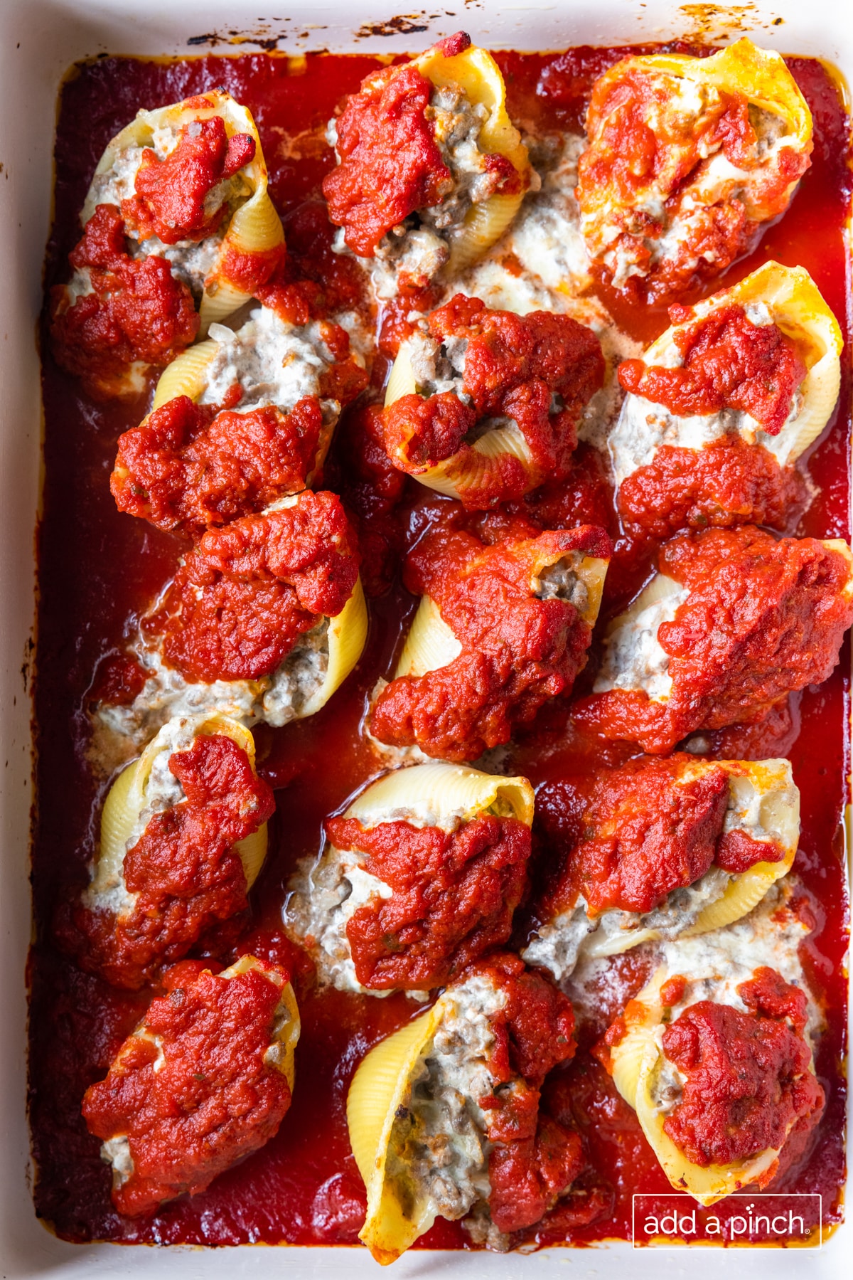 Photo of stuffed shells in a baking dish ready to be served. 