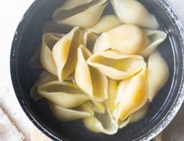 Photo of cooked pasta shells in a pot.
