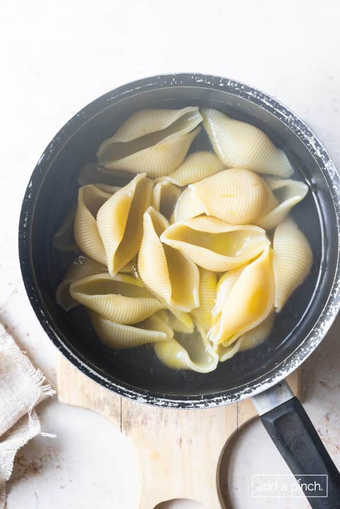 Photo of cooked pasta shells in a pot.