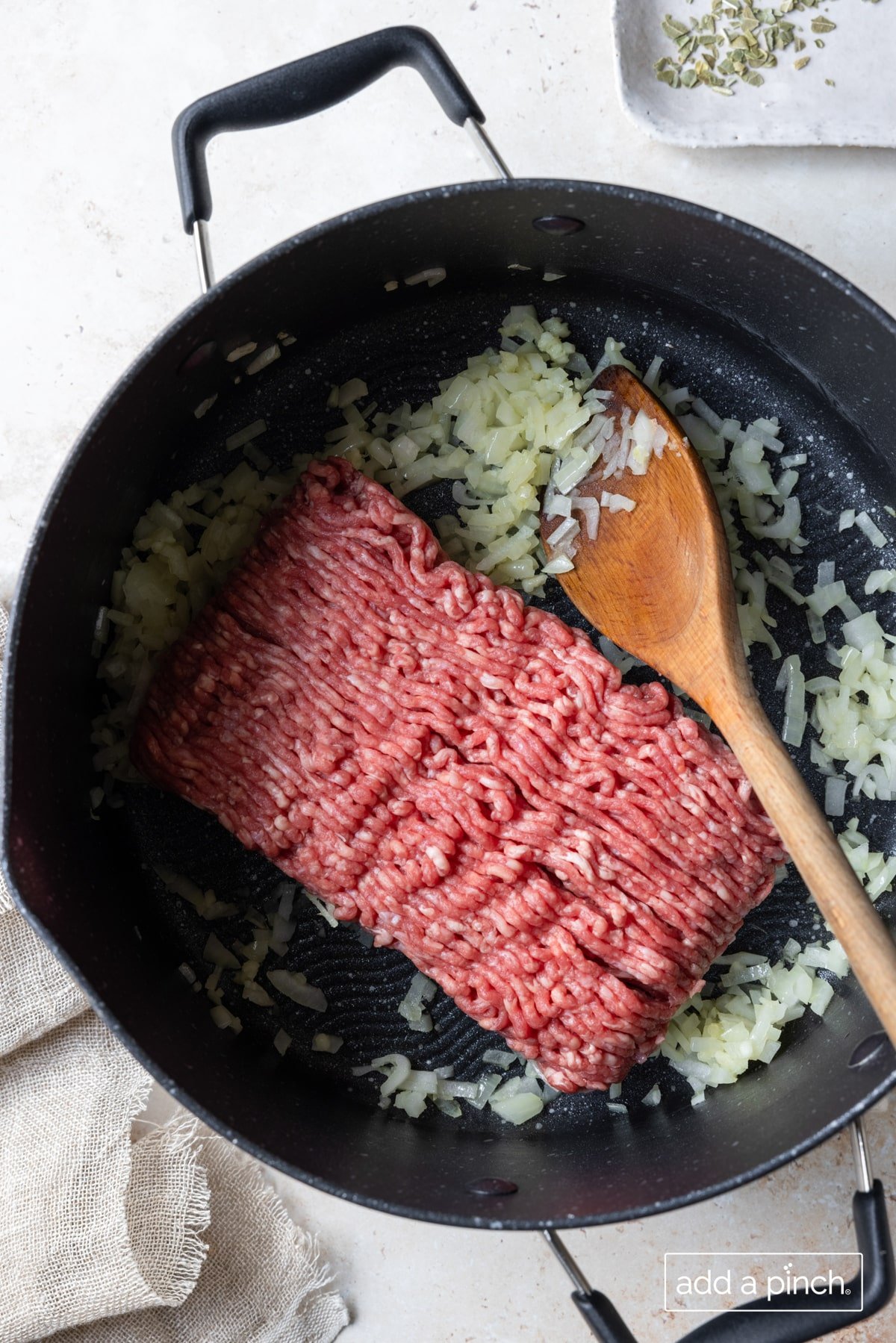 Photo of ground beef, onions and garlic cooking in skillet.