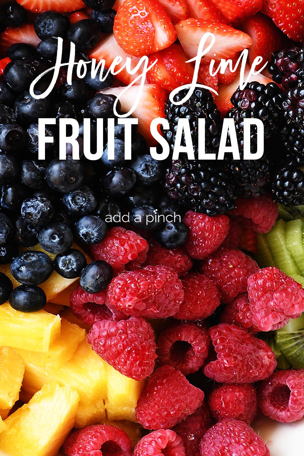 Honey Lime Fruit Salad with many colorful fresh fruits mixed in a tangy honey lime dressing - with text - addapinch.com
