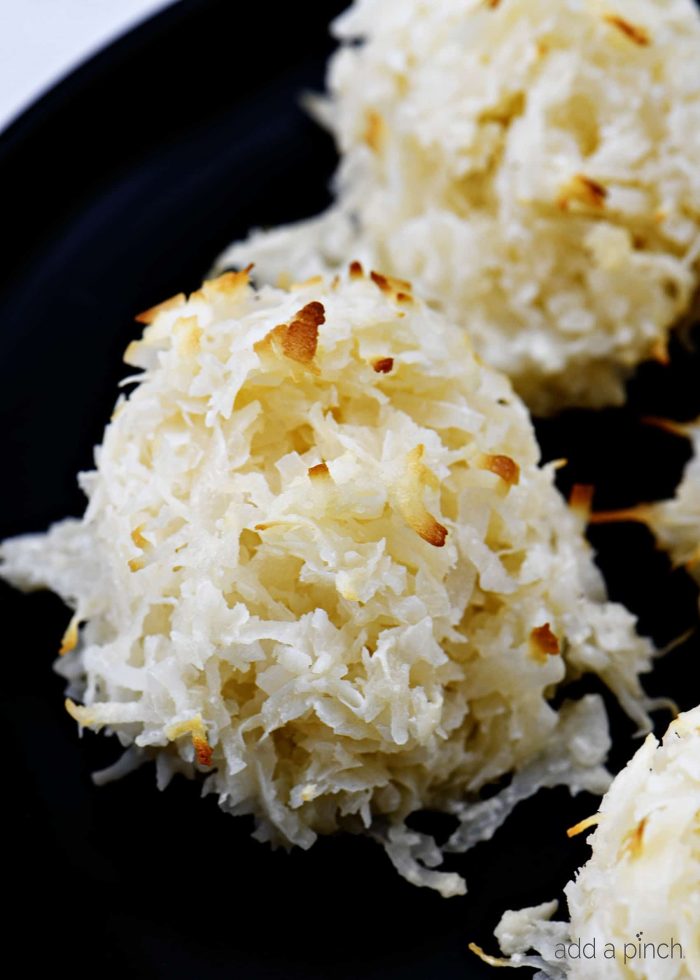 Coconut macaroons with golden brown flakes from baking, on a dish// addapinch.com