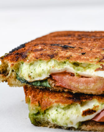 Caprese Grilled Cheese Sandwich Recipe - A delicious, gourmet grilled cheese made of sourdough, pesto, mozzarella, tomatoes, and fresh basil. // addapinch.com