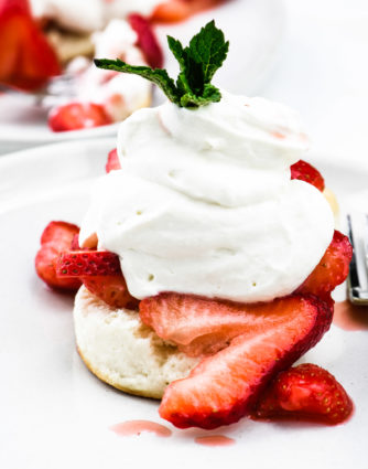 Strawberry Shortcake makes a classic dessert. Made of tender biscuits, topped with sweetened strawberries, and whipped cream, this simple strawberry shortcake is a favorite! // addapinch.com