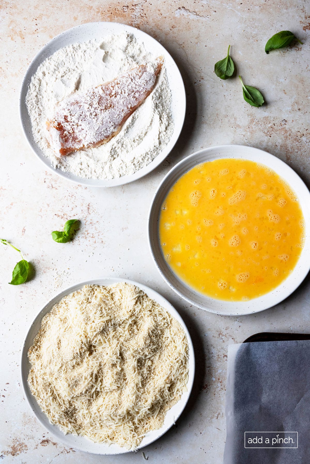 Photo of chicken breast being coated in flour.