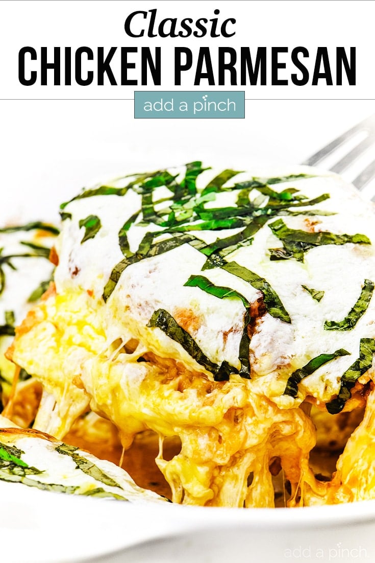 Classic Chicken Parmesan covered in cheese and topped with basil ribbons - with text - addapinch.com
