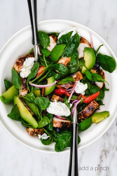 Grilled Chicken Salad with Strawberries and Avocado Recipe - This simple grilled chicken salad is made with fresh spinach, sweet berries and creamy avocado, then tossed with a quick balsamic dressing. Ready in 30 minutes! // addapinch.com