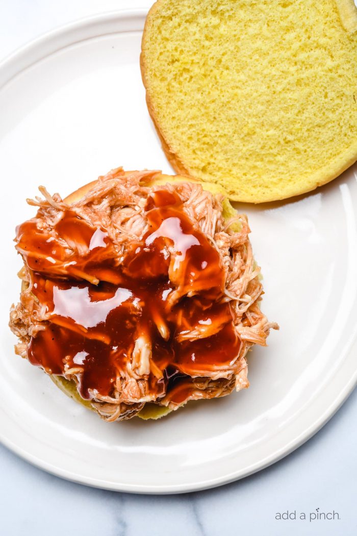BBQ Chicken Sandwiches make an easy and delicious meal! Made with shredded chicken tossed in a flavorful BBQ sauce! Always a favorite! // addapinch.com