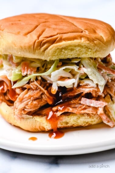 BBQ Chicken Sandwiches make an easy and delicious meal! Made with shredded chicken tossed in a flavorful BBQ sauce! Always a favorite! // addapinch.com
