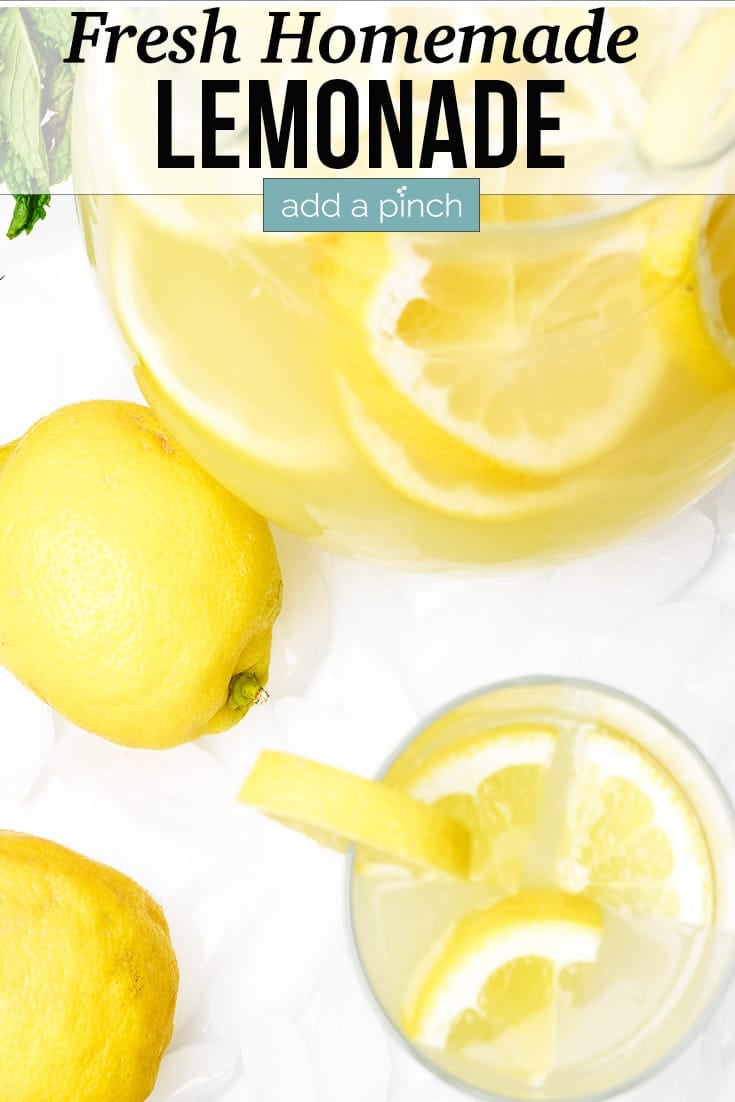Lemonade - Pitcher of fresh lemonade and two glasses full garnished with lemon and fresh mint on a bed of ice cubes - with text - from addapinch.com