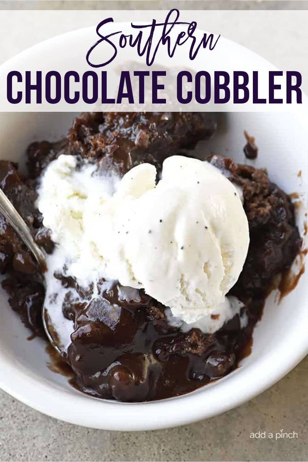 Bowl of chocolate cobbler topped with vanilla ice cream - with text - addapinch.com