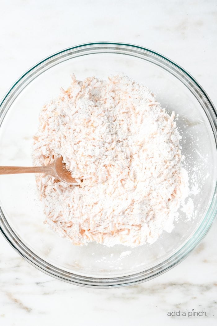 Flour and cheese mixed in a glass bowl.