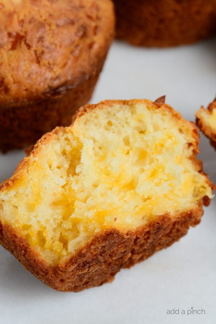 Cheesy muffin cut in half with melty cheese showing  // addapinch.com