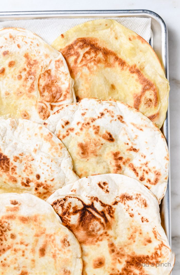 Crispy flour tortillas on a baking sheet // addapinch.com