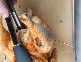 Photo of transferring chicken to the Instant Pot trivet with handles on a parchment-lined baking sheet. // addapinch.com