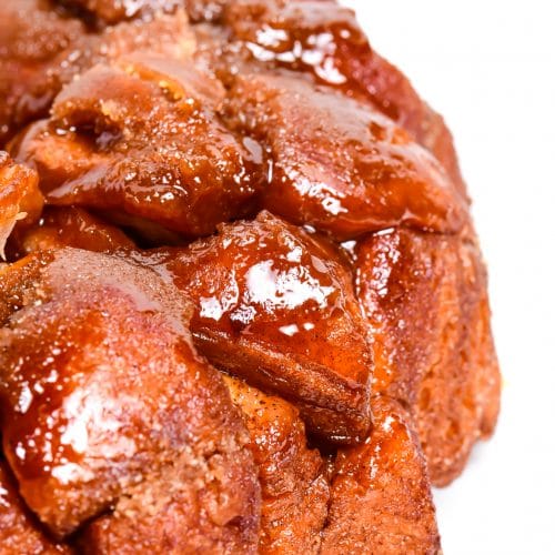 photograph of golden brown monkey bread with a caramel glazed on a white platter. // addapinch.com
