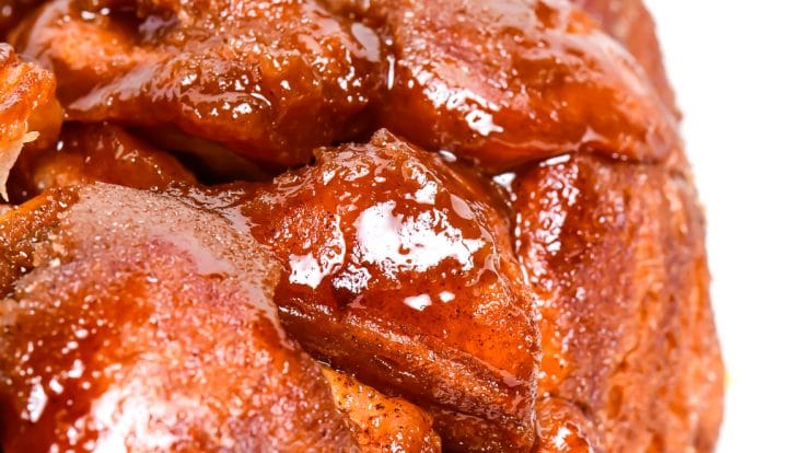 photograph of golden brown monkey bread with a caramel glazed on a white platter. // addapinch.com