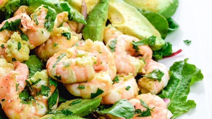 Photograph of Citrus Shrimp Avocado Salad on a white platter on white marble. // addapinch.com