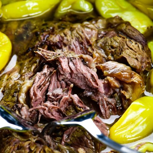 Photograph of Mississippi Roast with pepperoncini peppers in a slow cooker.