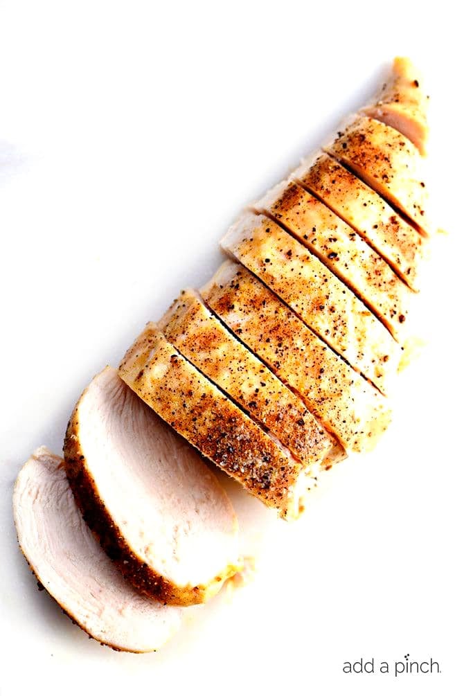 Sliced Baked Chicken Breast diagonally on a white board