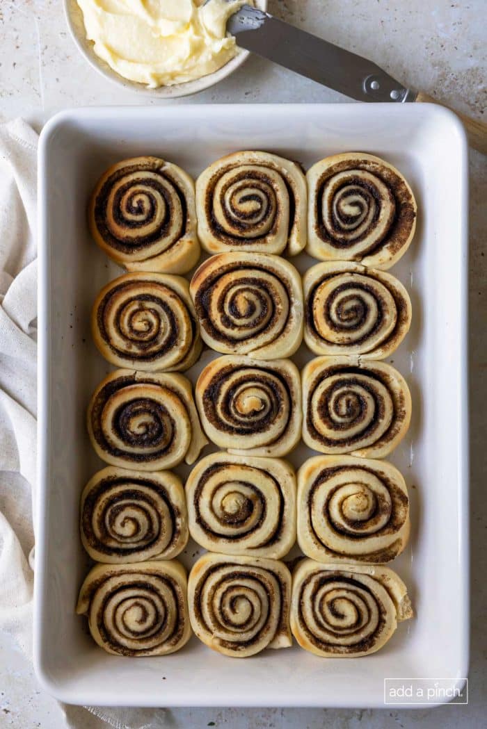 Photo of cinnamon roll slices in a white baking dish.