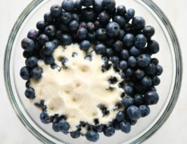 Blueberries and sugar in a glass bowl