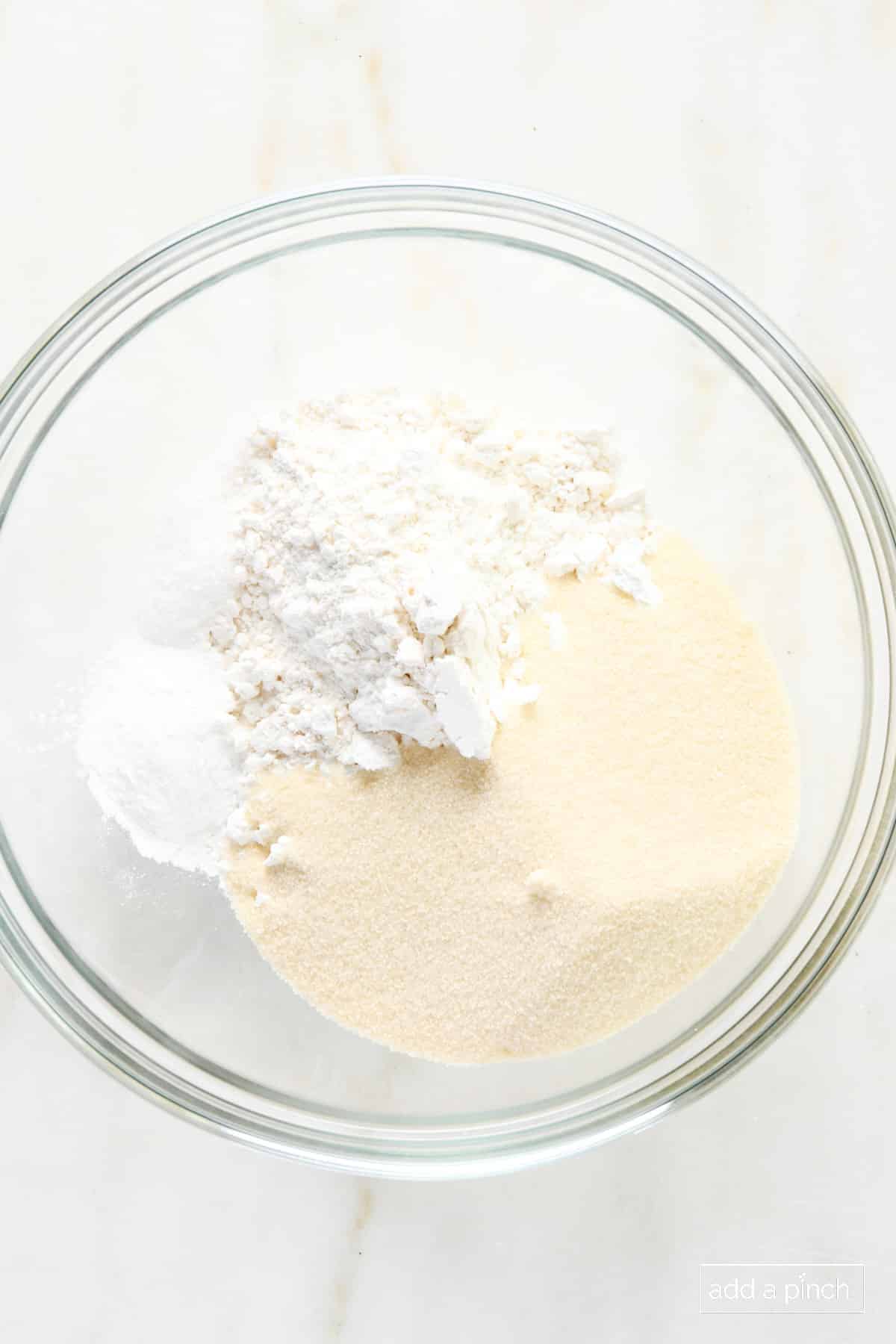 Flour, sugar, baking powder, and salt in a glass bowl.