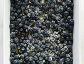 Sugared blueberries in a white baking dish.