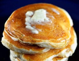 Photograph of buttermilk pancakes topped with butter and maple syrup. // addapinch.com
