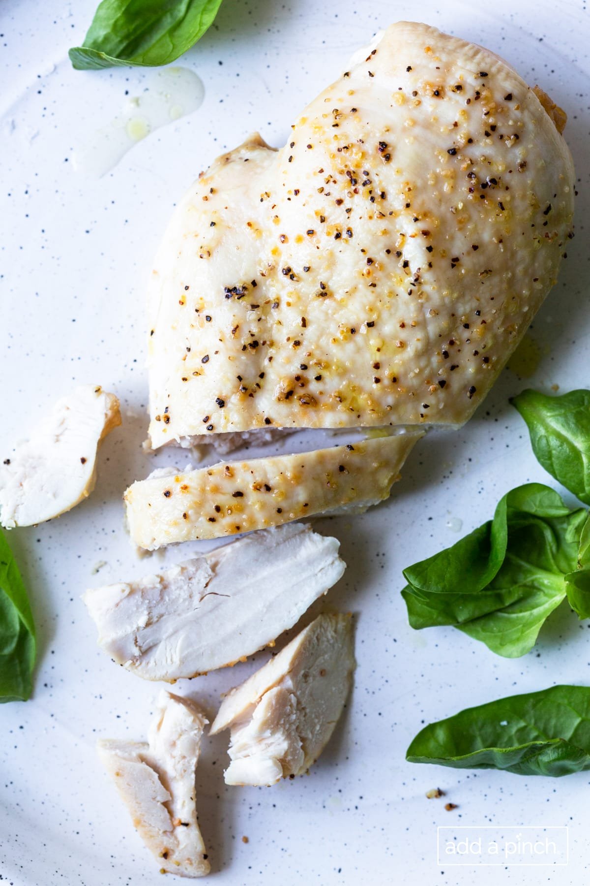 Photo of baked chicken breast on a white plate.