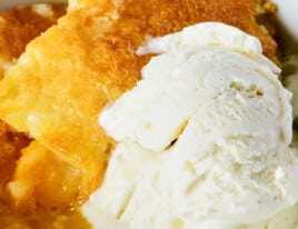 peach cobbler with ice cream in a white bowl