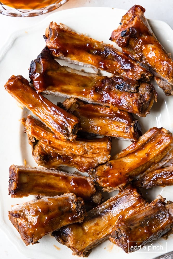 Ribs with bbq sauce on a white plate.
