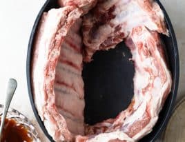 Rack of ribs arranged in a slow cooker.