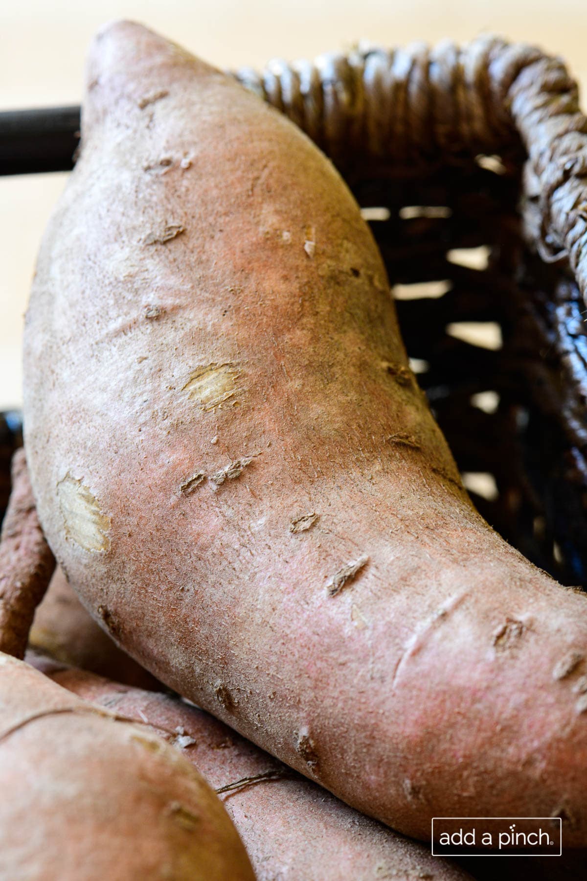Closeup photo of a sweet potato in a wicker basket.