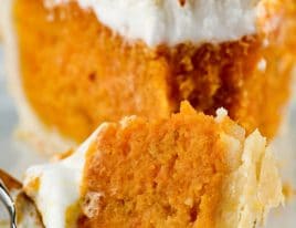 Closeup photograph of slice of sweet potato pie on a white plate.