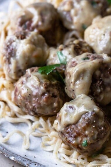 Photo of swedish meatballs served on a bed of noodles.