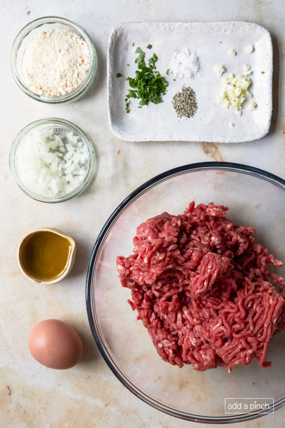 Photo of ingredients to make swedish meatballs. Ground beef, egg, worcestershire sauce, onion, cracker crumbs, and seasonings.