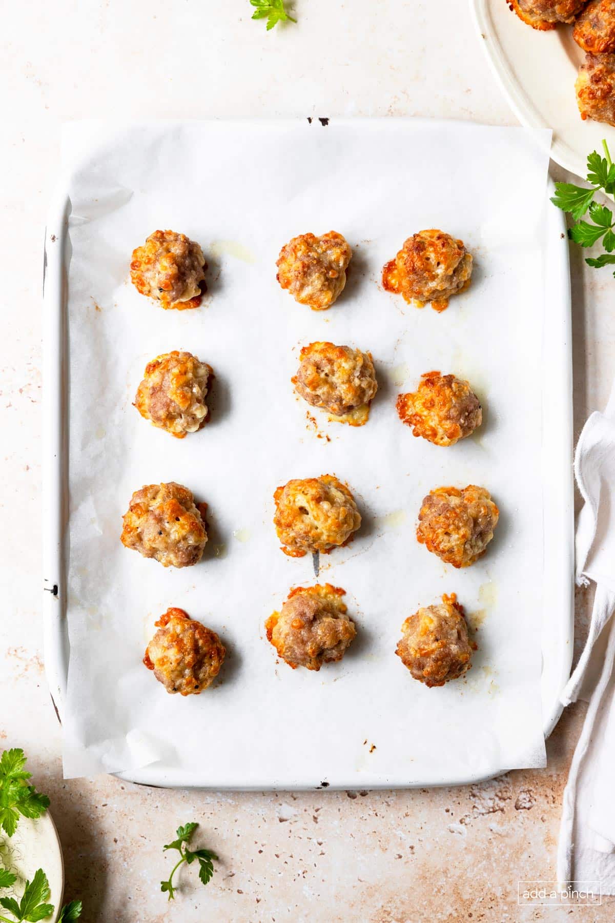 Overhead image of baked sausage balls on a parchment lined baking sheet.