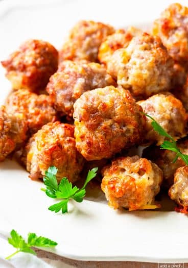Photo of cooked sausage balls on a white serving plate.
