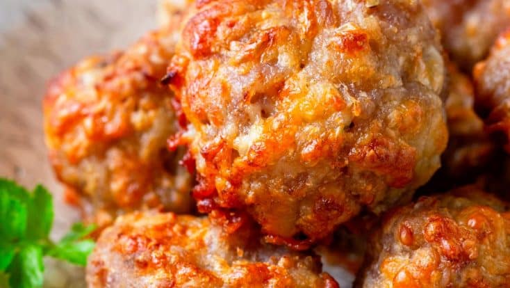 Photo of cooked sausage balls in a white serving bowl.